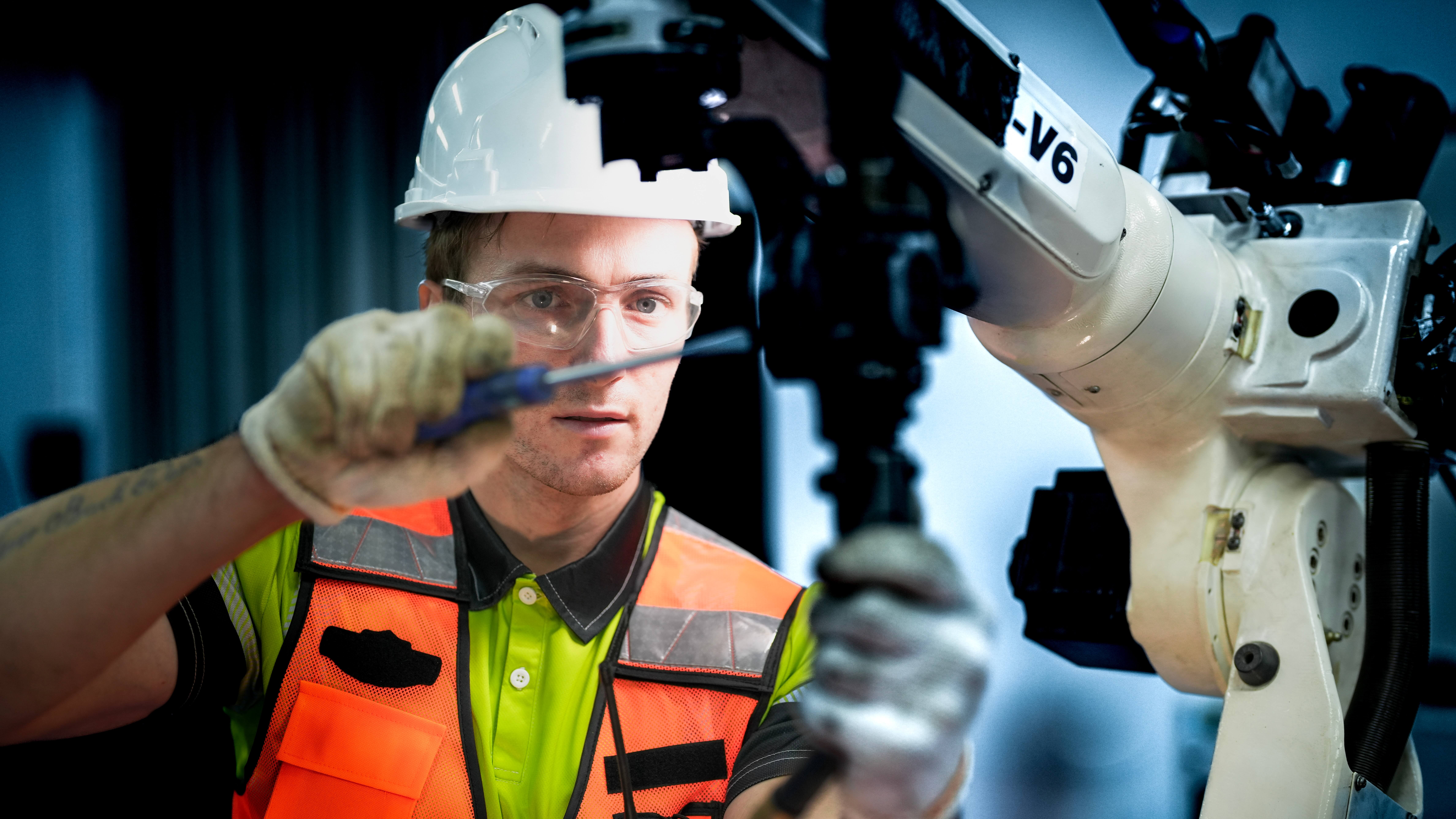 An,Engineer,Programs,Or,Repairs,A,High-tech,Industrial,Robot.,This
