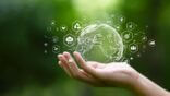 Globe,On,Hand,In,Green,Forest,With,Icon,Of,Sustainable